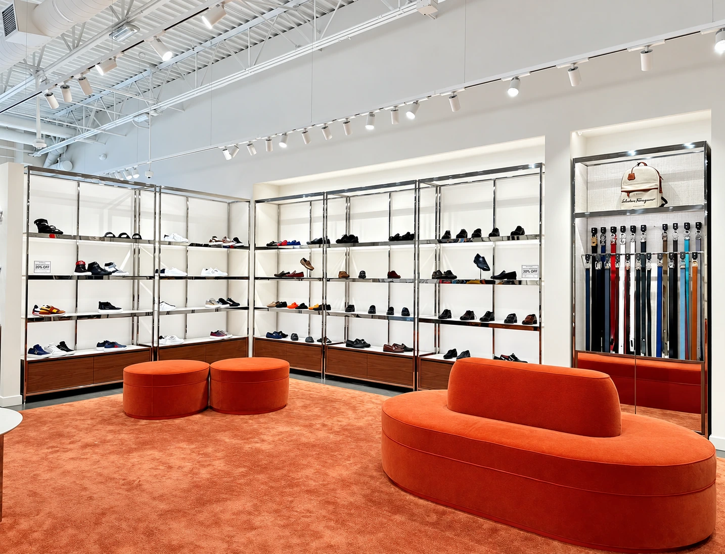 Retail interior with white track lighting, illuminated displays and orange seating